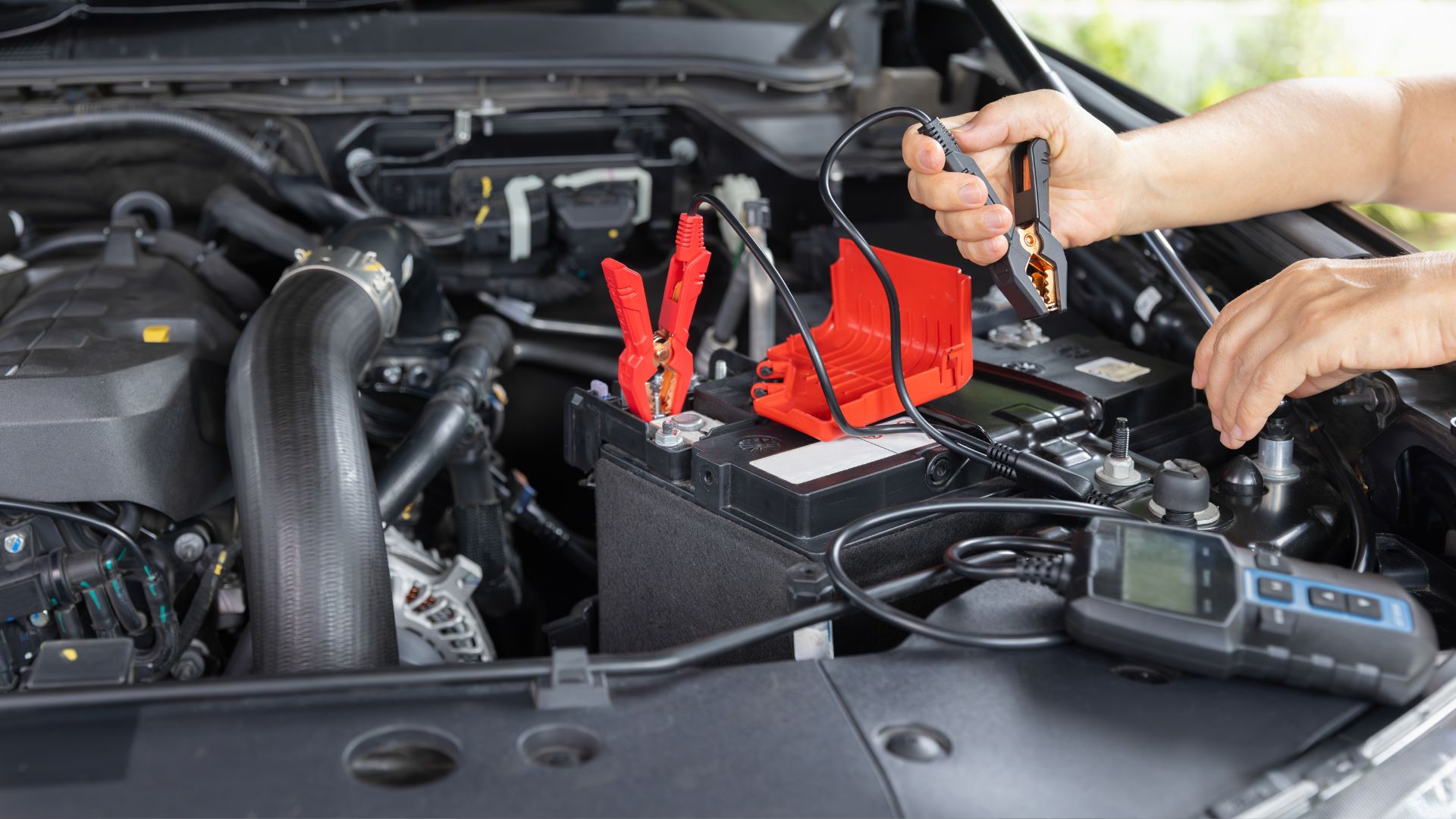 A person is working on a car's battery